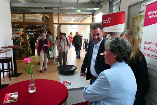 Ein Messestand mit mehreren Personen in einem Foyer.
