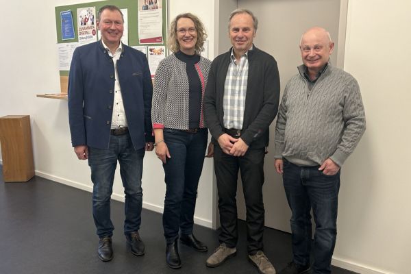 Vier Personen lächeln in die Kamera Vier Personen lächeln freundlich in die Kamera