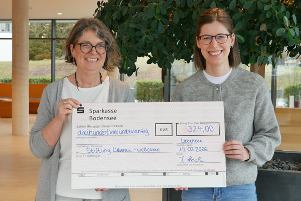 Spendenübergabe Zwei Frauen halten einen Scheck bei einer Spendenübergabe im Foyer.