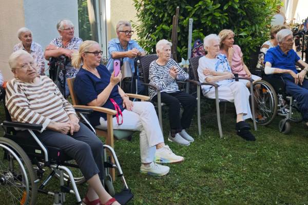 Sommerfest mit Show-Programm im Haus St. Pirmin Das Bild zeigt Zuschauer im Halbrund im Garten sitzend beim Sommerfest im Haus St. Pirmin