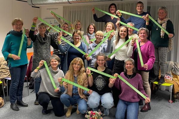 Eine Menschengruppe lacht in die Kamera