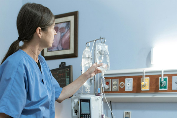 Reportage Eine Frau in Arbeitskleidung im Krankenhaus.