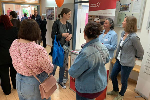 Mehrere Personen unterhalten sich in einem Foyer.