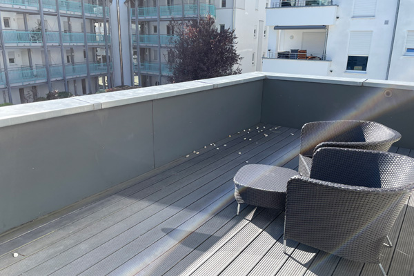 Das Foto zeigt die Terrasse mit einem Tisch und zwei Stühlen.