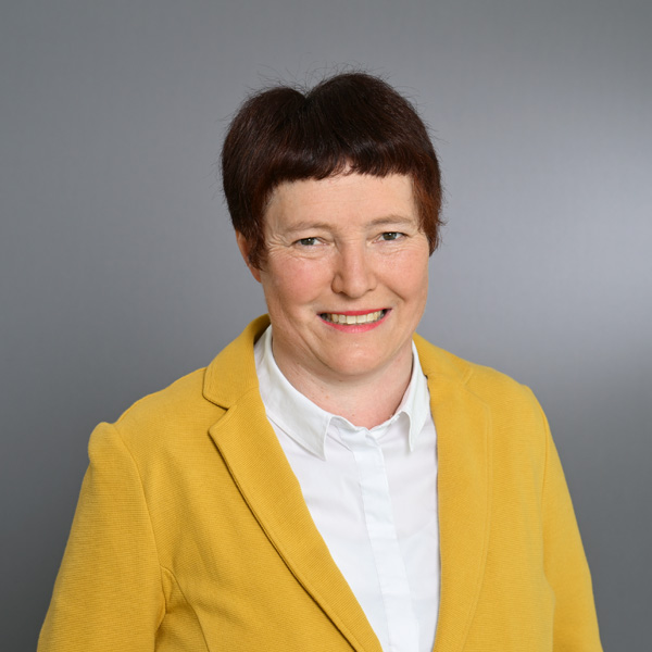 Eine Frau lächelt in die Kamera für ein Portraitfoto.