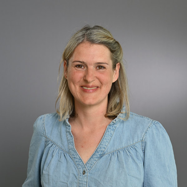 Eine Frau lächelt in die Kamera für ein Portraitfoto.