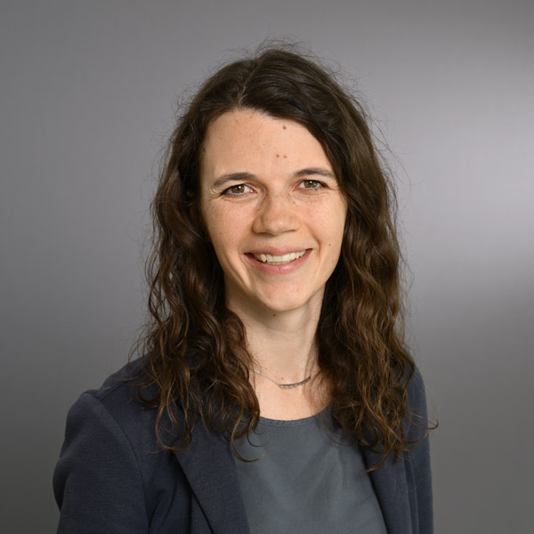 Eine Frau lächelt in die Kamera für ein Portraitfoto.