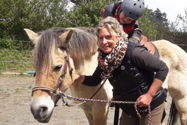 Das Bild zeigt eine Frau mit einem Pferd