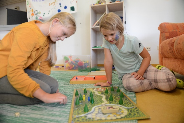 Das Bild zeigt zwei Kinder mit einem Brettspiel